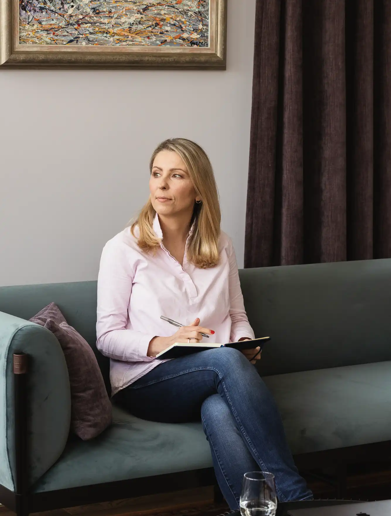 Dagmara Seliga‑Krawczyńska siedzi z notatnikiem i długopisem na sofie, w chwili refleksji – proces pracy z klientem