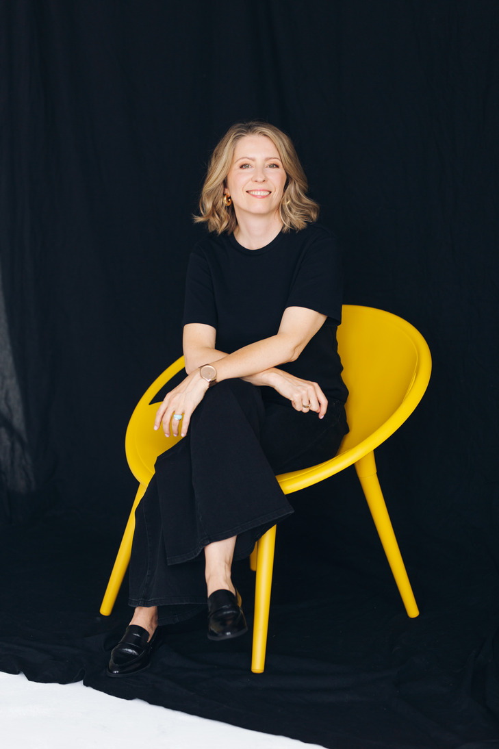 Dagmara Seliga siedząca na żółtym krześle, uśmiechnięta i spokojna – coach wspierająca kobiety w działaniu z odwagą i autentycznością.